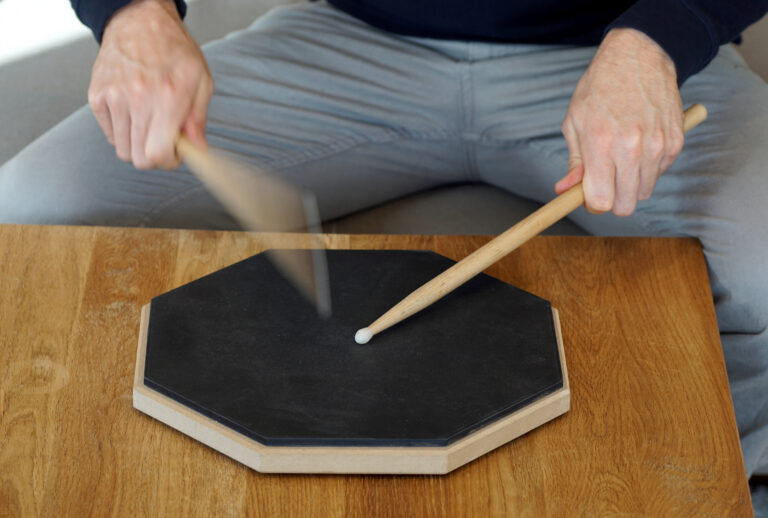 man drumming on a practice pad at home