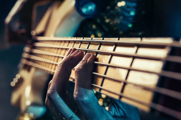 Closeup photo of bass guitar player hands