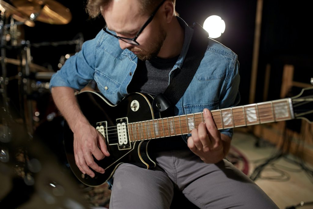 man-playing-guitar-at-studio-rehearsal